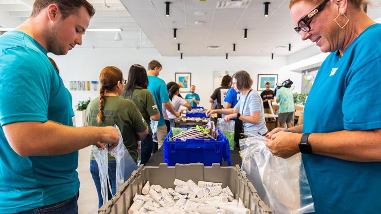 United Way volunteers standing while assembling heat relief kits in Phoenix