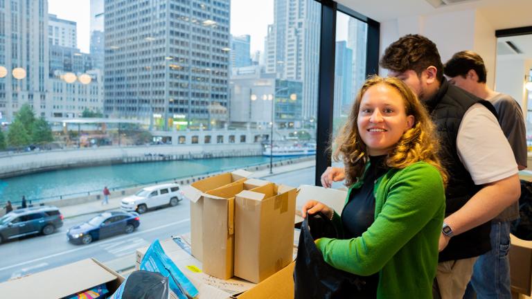 A woman wearng a green sweater helps assemble emergency kits at a recent United Way of Chicago Young Leaders event