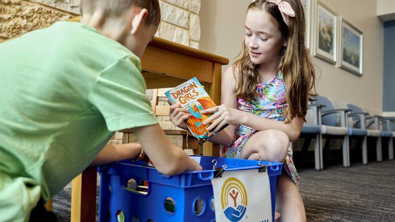 Two children looking at books in a library