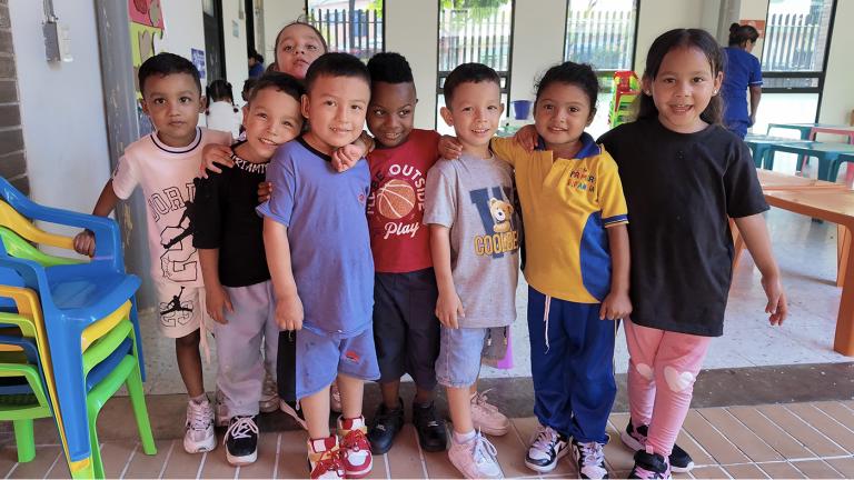 A group of young schoolchildren in Colombia standing together and smiling at the camera