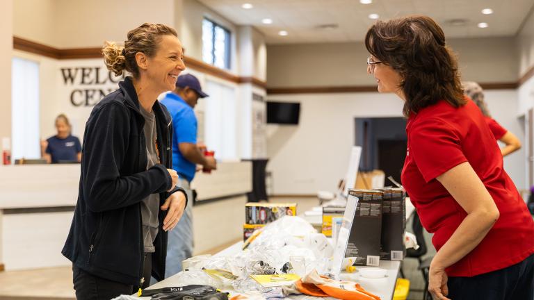 A United Way staffer helps welcome a woman to a flooding relief center in Indiana.