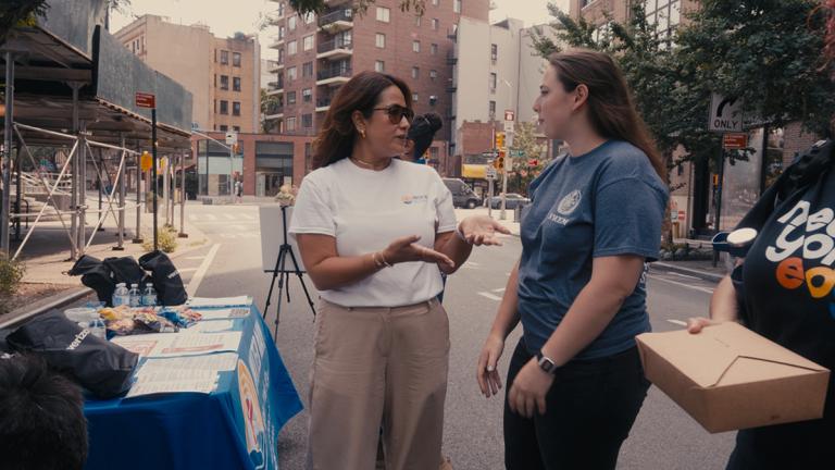 United Way of New York City's Alessandra Angarita talking with a Resiliency Ambassador durnig a community block party