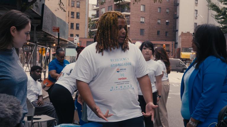 Resiliency Ambassador Sha-King Smith interacting with people at a block party.