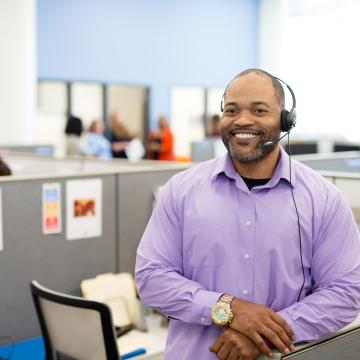 Man in purple shirt with 2-1-1 headset on