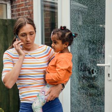 Woman holding child while on the phone