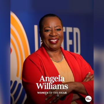 Angela F. Williams posed in front of a United Way logo with "Woman of the year" written on it