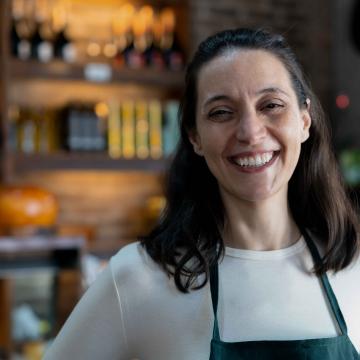Woman working in a market wearing an apron.