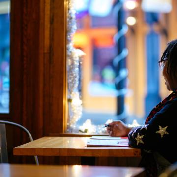 Woman sitting in a coffee shop looking out of the window