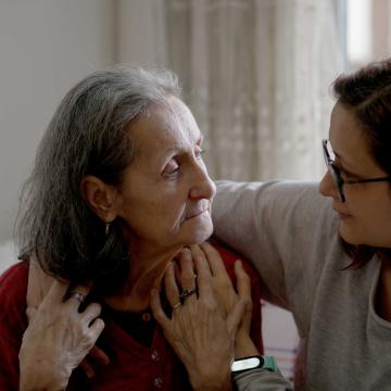 A woman with her arm around an elderly womn