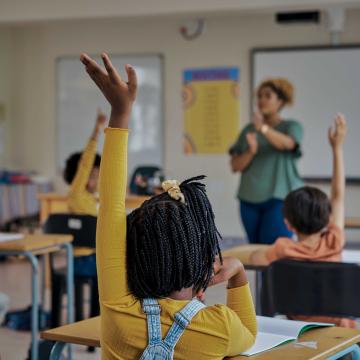 Children raising their hands in a classroom