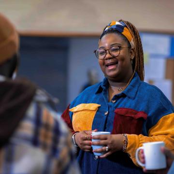 Woman holding a coffee mug in a small group