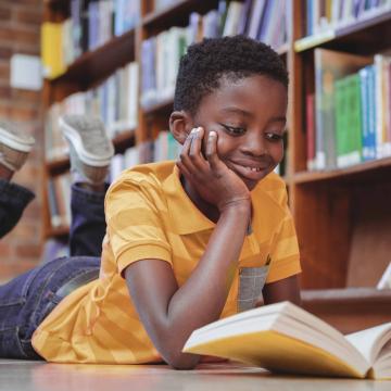 Boy reading a book in a library