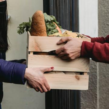 Two individuals exchanging a crate of food