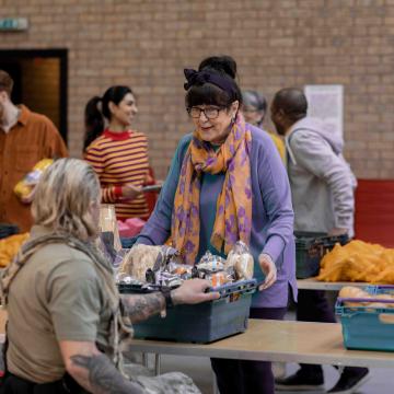 Volunteer supplying food to a person in need.