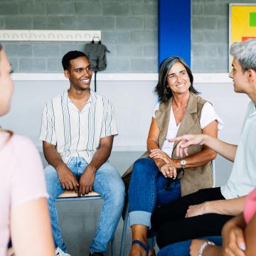 Young adults sitting in a support circle of peers