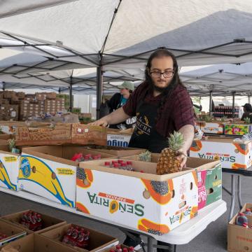 Worker at a food distribution site under a tent