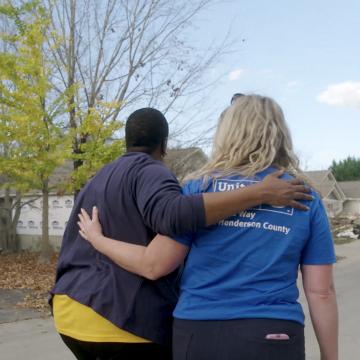 United Way staff members walking through debris after a hurricane