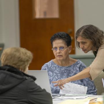 VITA volunteer helps community member file her taxes.