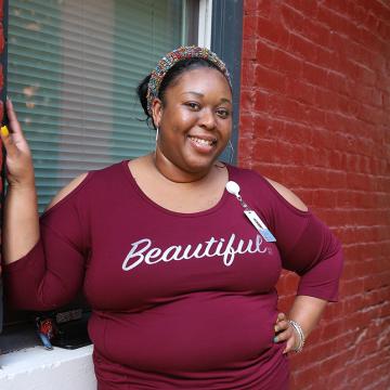 Ariel smiling wearing shirt that says beautiful. 