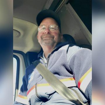 Letter carrier Russell smiling in his vehicle