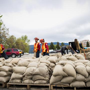 workers pile up sandbags to prepare for a flood