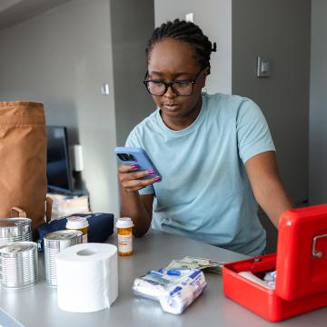 Woman packing a go back and looking at mobile device
