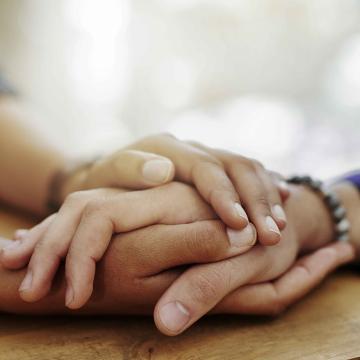 close up of two people holding hands