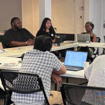 Attendees gather around tables at a United We Prepare workshop