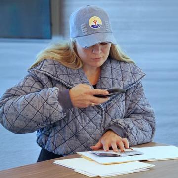 A woman using her phone to take a picture of a document