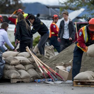 Workers stack sandbags to prevent flooding damage