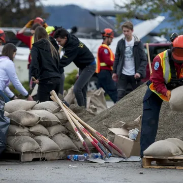Workers stack sandbags to prevent flooding damage
