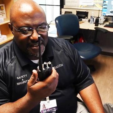Hospital safety and security staffer talking into new radio