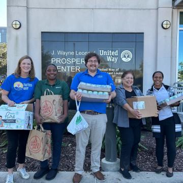 United Way of Southeast Louisiana staff hold boxes of food