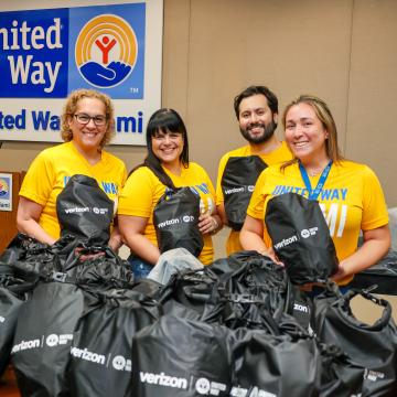 United Way Miami staff smiling as they fill emergency preparedness kits