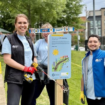 Voluneers in Alexandria, Va. smile and hold a level and shovel as they work to install a Born Learning STEAM Trail for children up to age 8 to teach Science, Technology, Engineering, Art, and Math (STEAM) concepts through interactive, outdoor exploration.