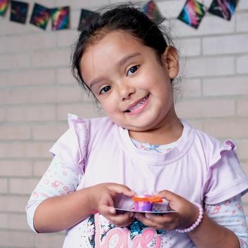 Emily, a five-year-old student at United Way Colombia's learning center in Bogotá's Bosa neighborhood, holding artworka 