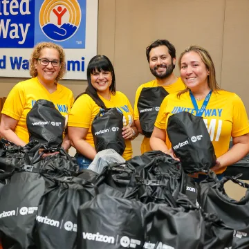 United Way Miami staff hold up Verizon emergency preparedness kits offered as part of the United We Prepare initiative