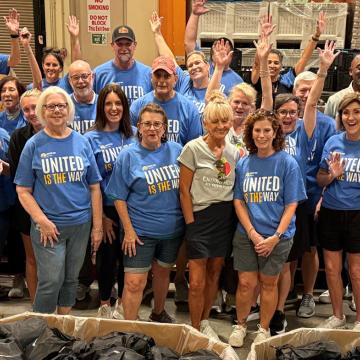 A group of 25 United Way Suncoast Volunteers standing and cheering 
