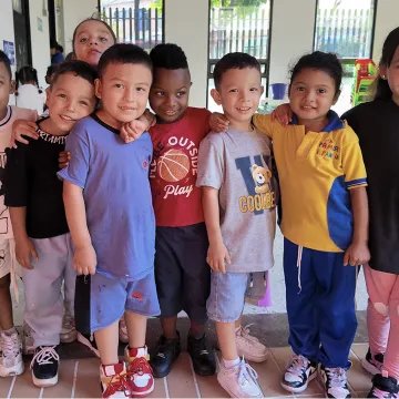 A group of young schoolchildren in Colombia standing together and smiling at the camera