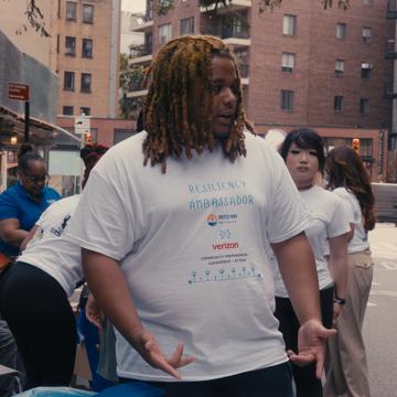 Resiliency Ambassador Sha-King Smith interacting with people at a block party.