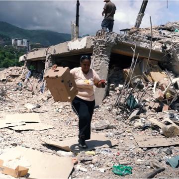 A woman walking through the rubble in the wake of Venezuelan earthquakes.