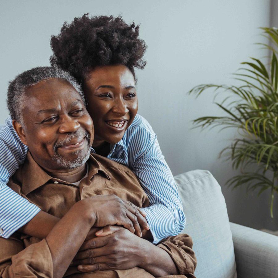 Grown woman hugging her dad on the couch