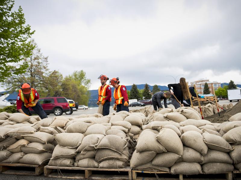 Workers stacking sandbags to prepare for flooding