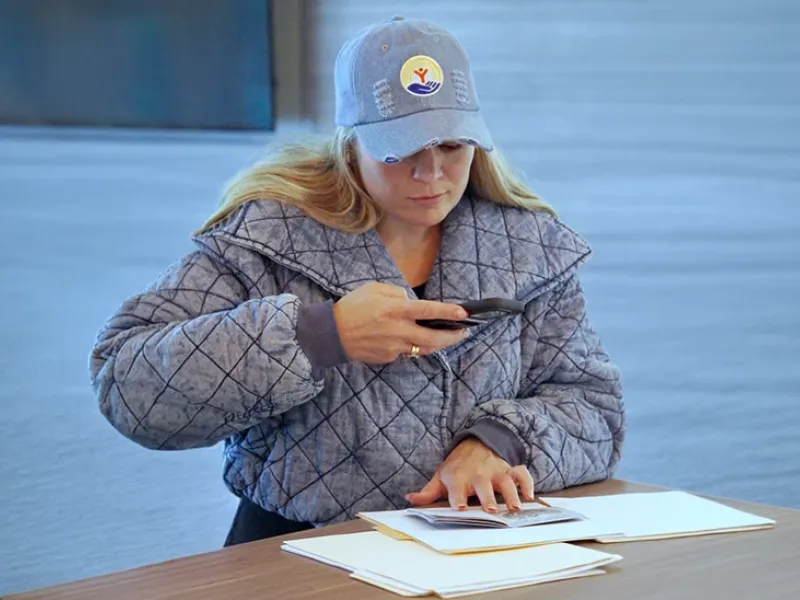 A woman using her phone to take a picture of a document