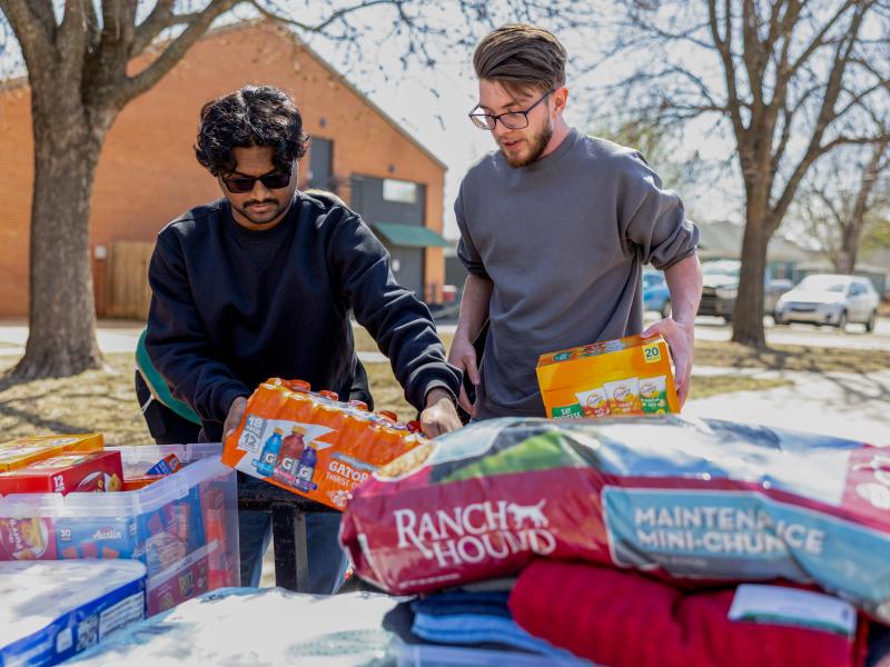 Two men stacking pet food
