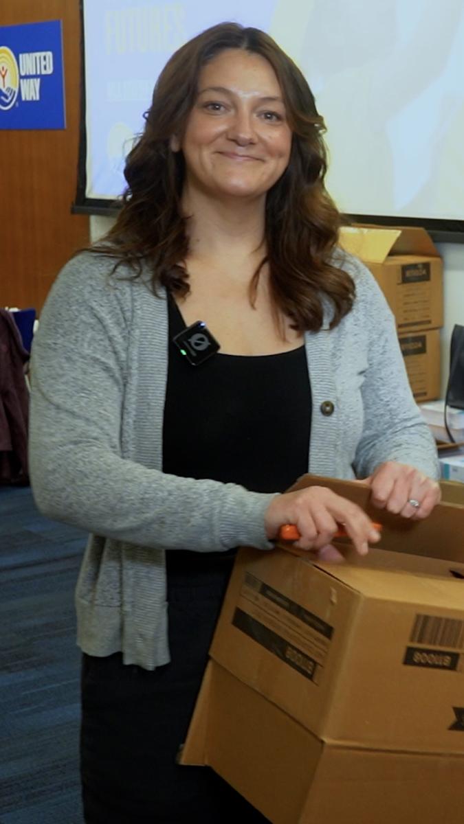 Aimee smiling while opening box