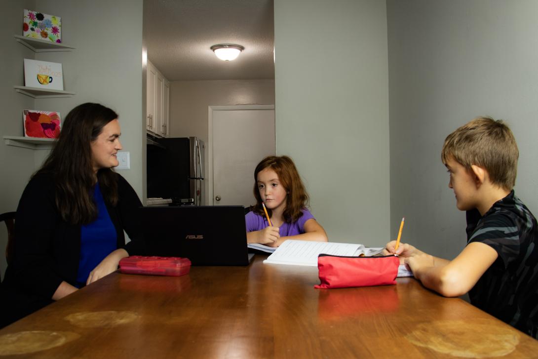 Kids doing homework at the kitchen table.