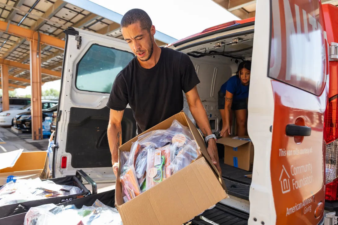 A United Way volunteer loads heat relief kits into a van for distribution